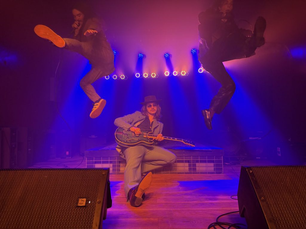 Three musicians jumping on stage at Feedback Music Lounge