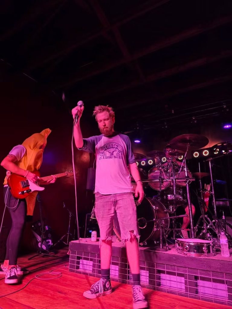 Singer with a microphone and a guitarist in a banana hood